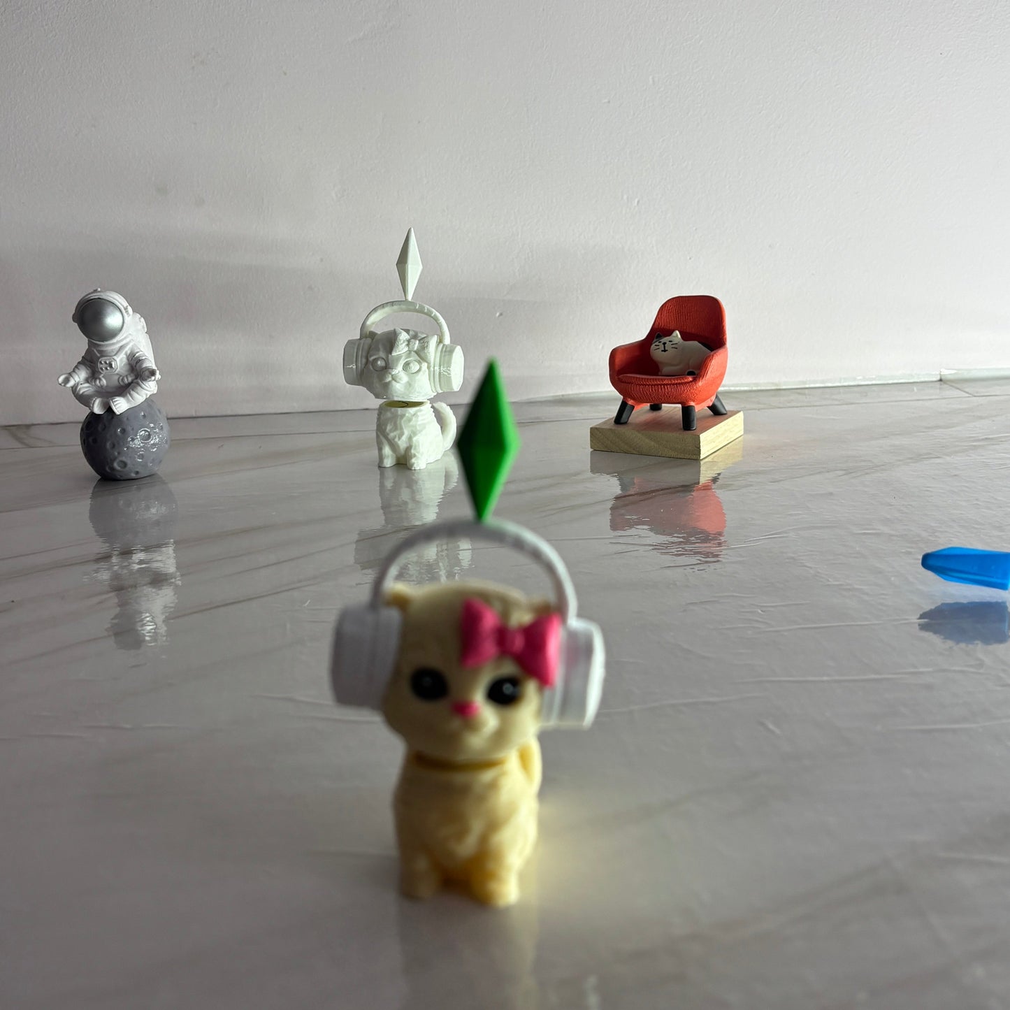 Small figurine with headphones and a bow on a reflective surface