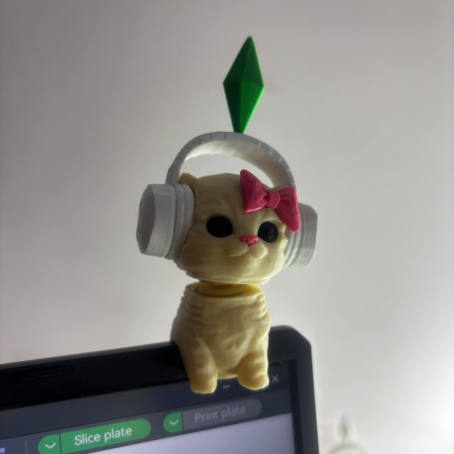 Small plush toy with headphones and a bow on a computer screen