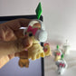 Small figurine with headphones held by a hand in front of a laptop screen