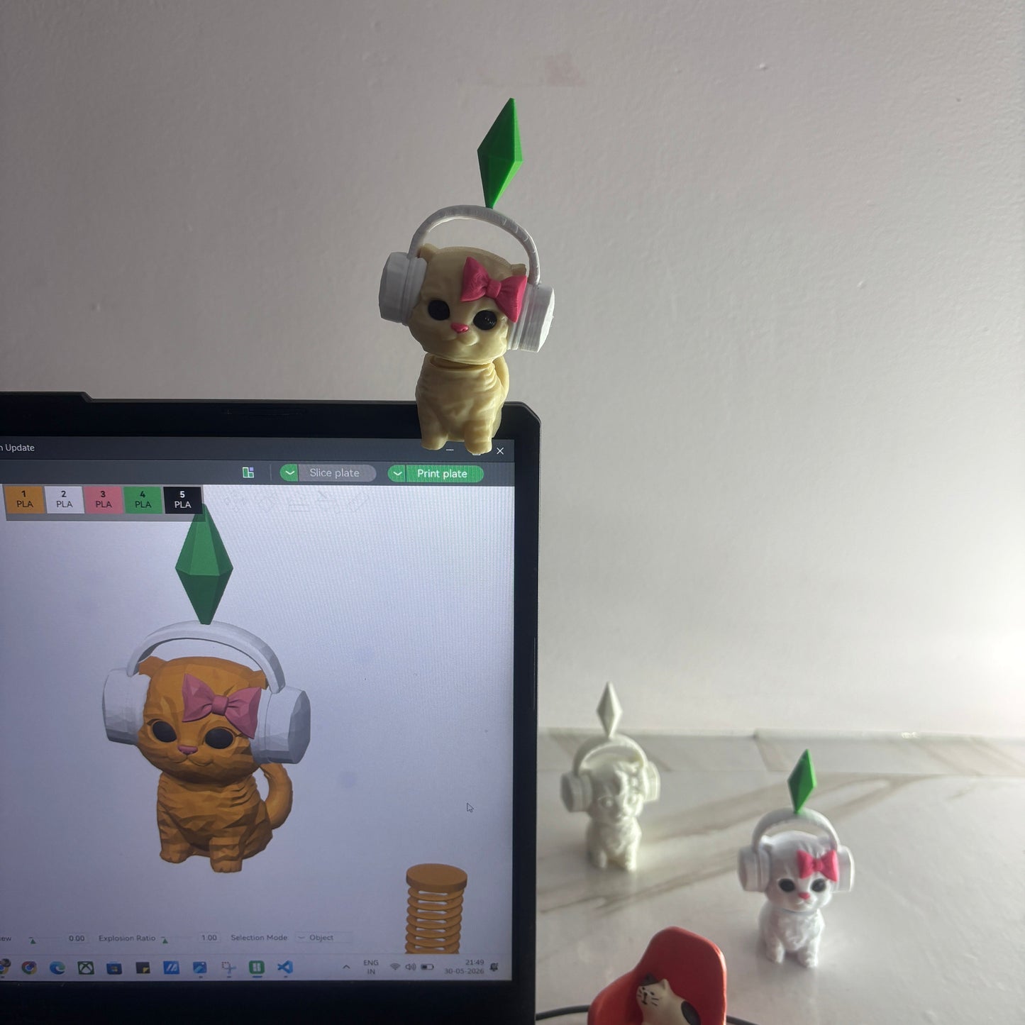 Toy figure interacting with a digital device displaying a character on a white wall background