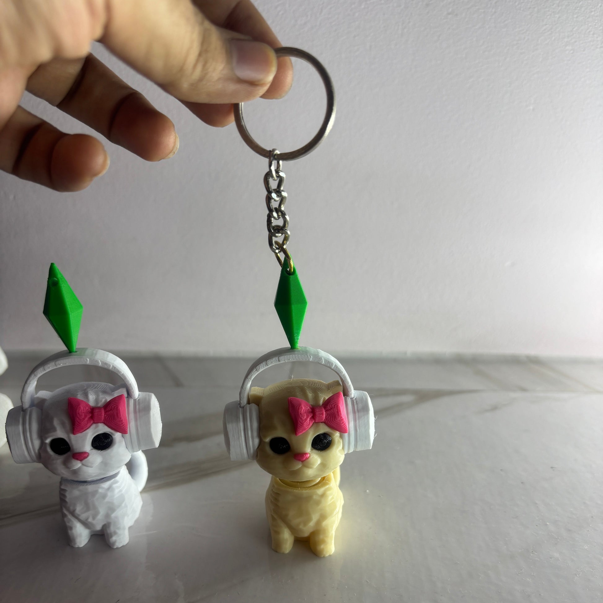 Two small animal figurines with headphones and bows, one white and one yellow, on a plain background.
