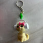 Keychain with a cartoonish character on a metallic surface