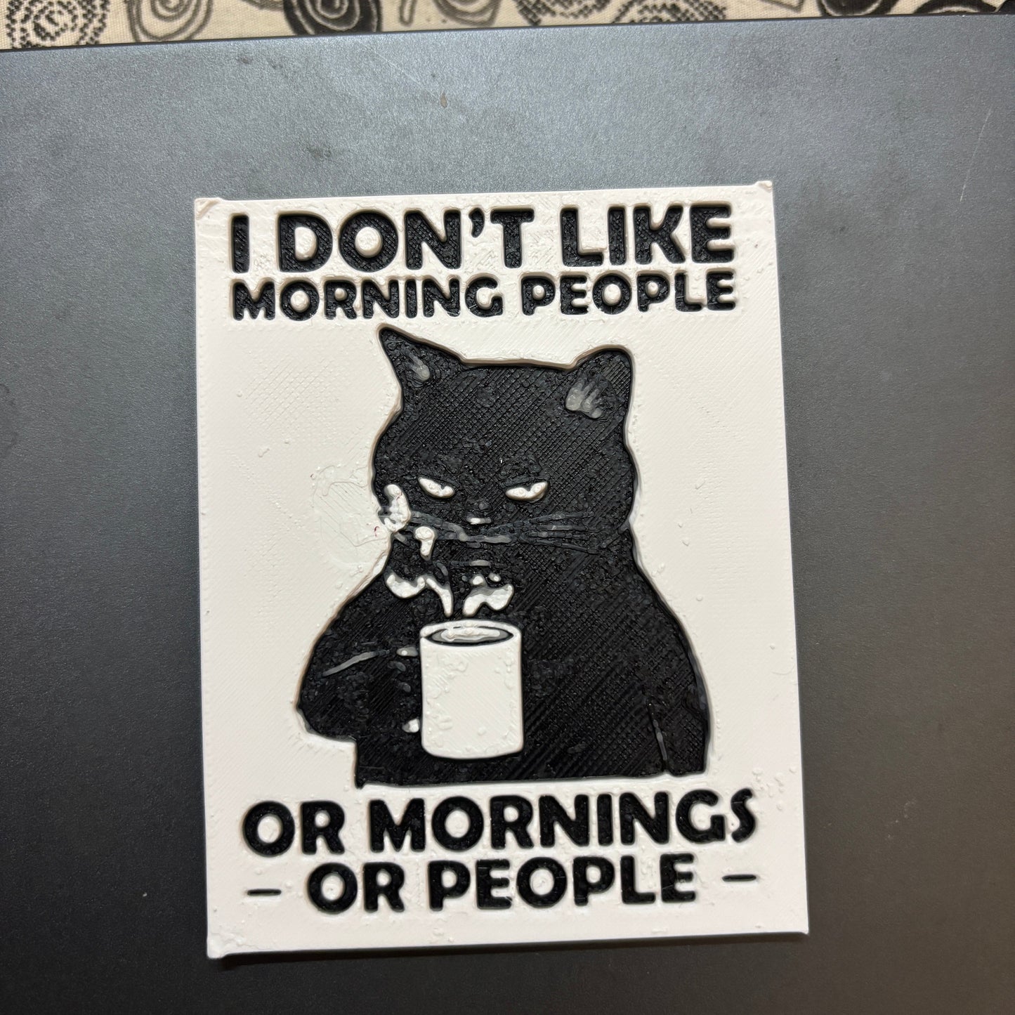 Sticker with a black cat and text on a metallic surface