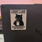 Sticker with a cat and text on a black surface