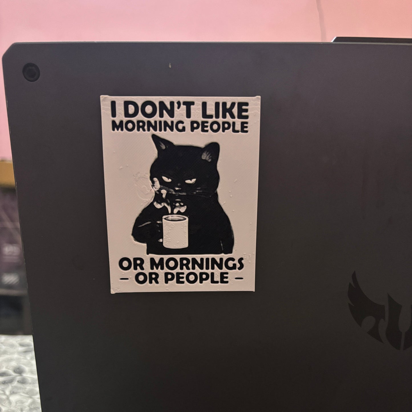 Sticker with a cat and text on a black surface