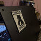 Sticker on a laptop with text 'I don't like morning people or mornings or people' on a dark background.